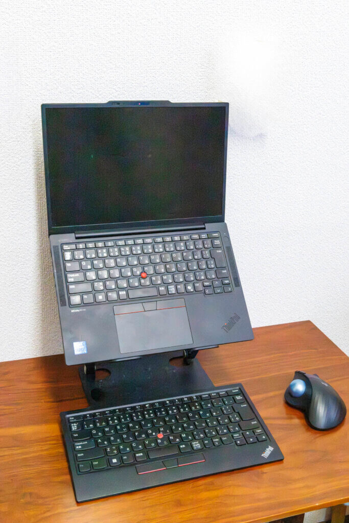 スタンドに載せたThinkPadと、手前に置いたトラックポイント キーボードIIとトラックボールのデスク環境