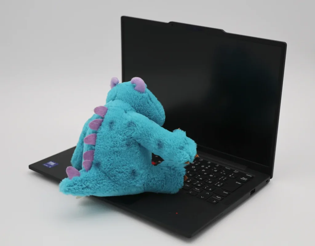 キーボードにぬいぐるみを置き、電源オフの非光沢画面を斜めから写した様子